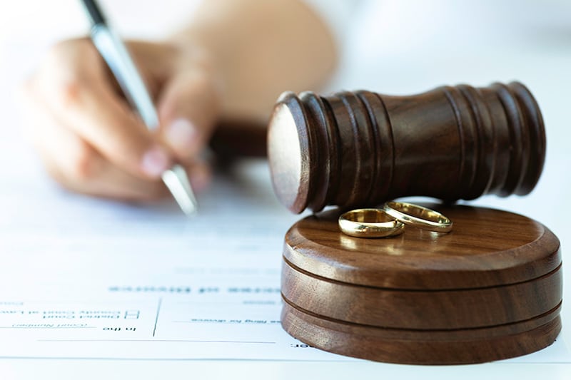 Gavel and wedding rings with divorce papers